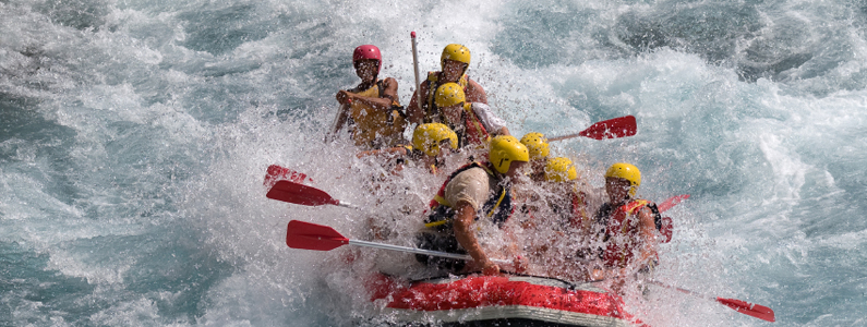 Otto persone in un gommone fanno rafting in mezzo alle rapide di un fiume