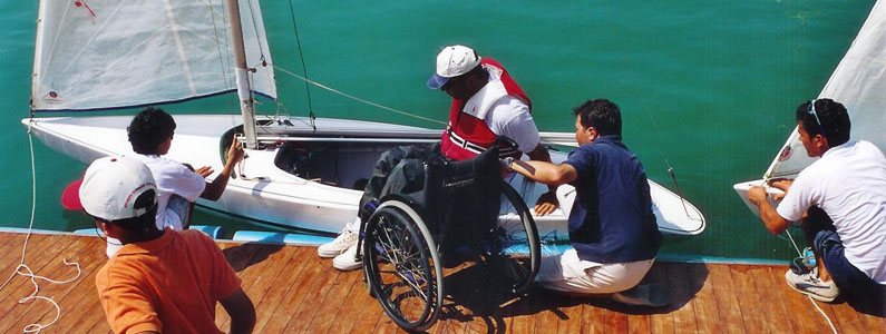 posizionamento di una persona con disabilità motoria, dalla sedia a ruote alla barca a vela