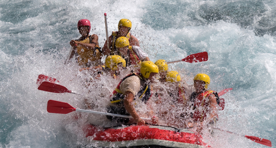 Gruppo di persone sfida le correnti su un gommone da rafting 