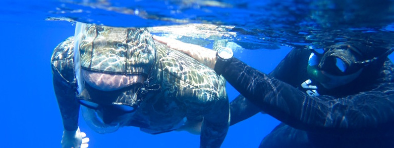 Istruttore guida persona con disabilità che nuota sotto la superficie dell'acqua