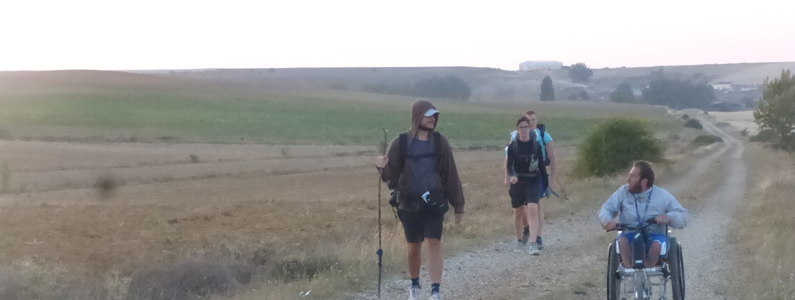 Gruppo di persone, tra cui uno in carrozzina, durante il cammino