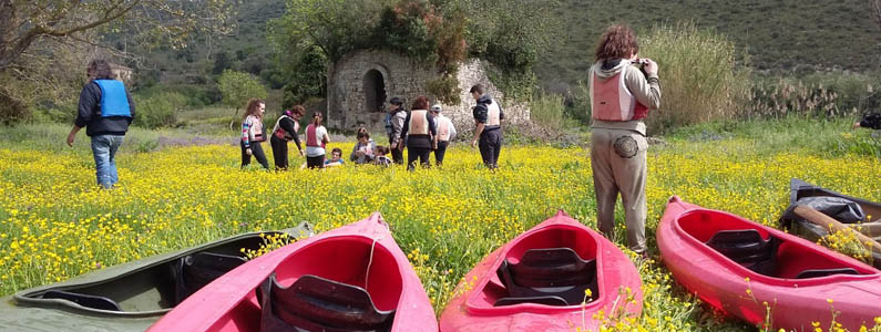 Canoe lasciate sull'argine del fiume, sullo sfondo gli escursionisti proseguono a piedi
