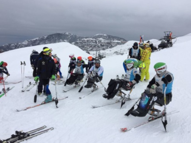 Gruppo di corsisti sciatori sitting pronti a partire