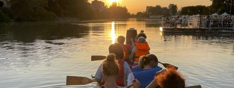 Donne di spalle che pagaiano al tramonto